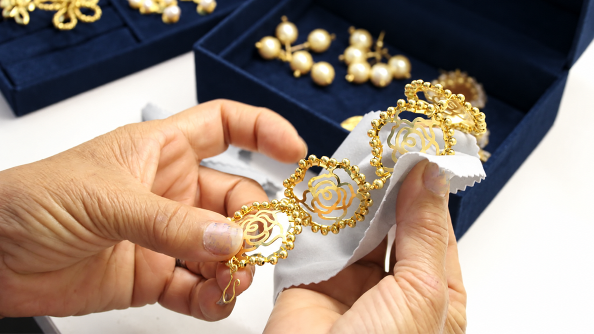 Gold jewelry being cleaned beside midnight-blue jewelry boxes