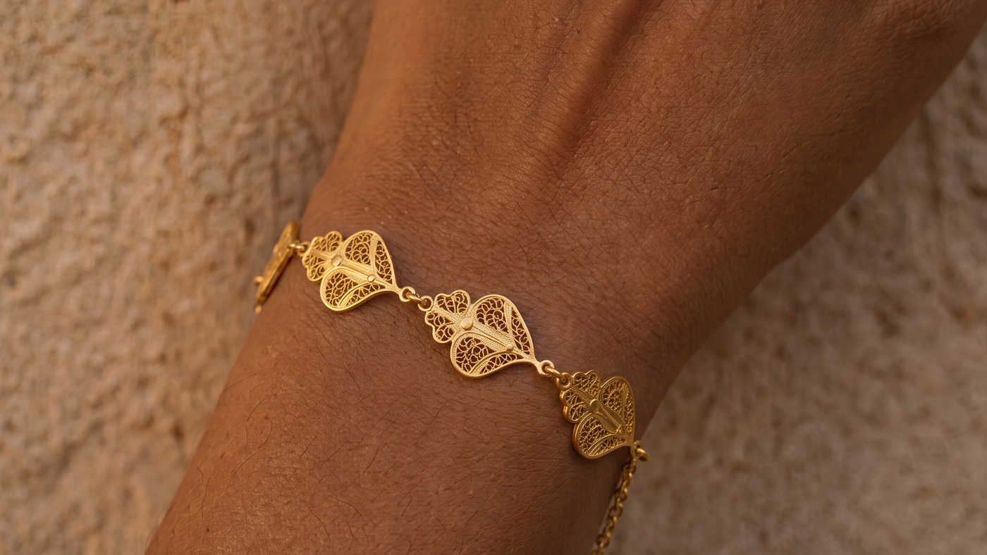 Intricate gold-colored filigree hearts on a bracelet