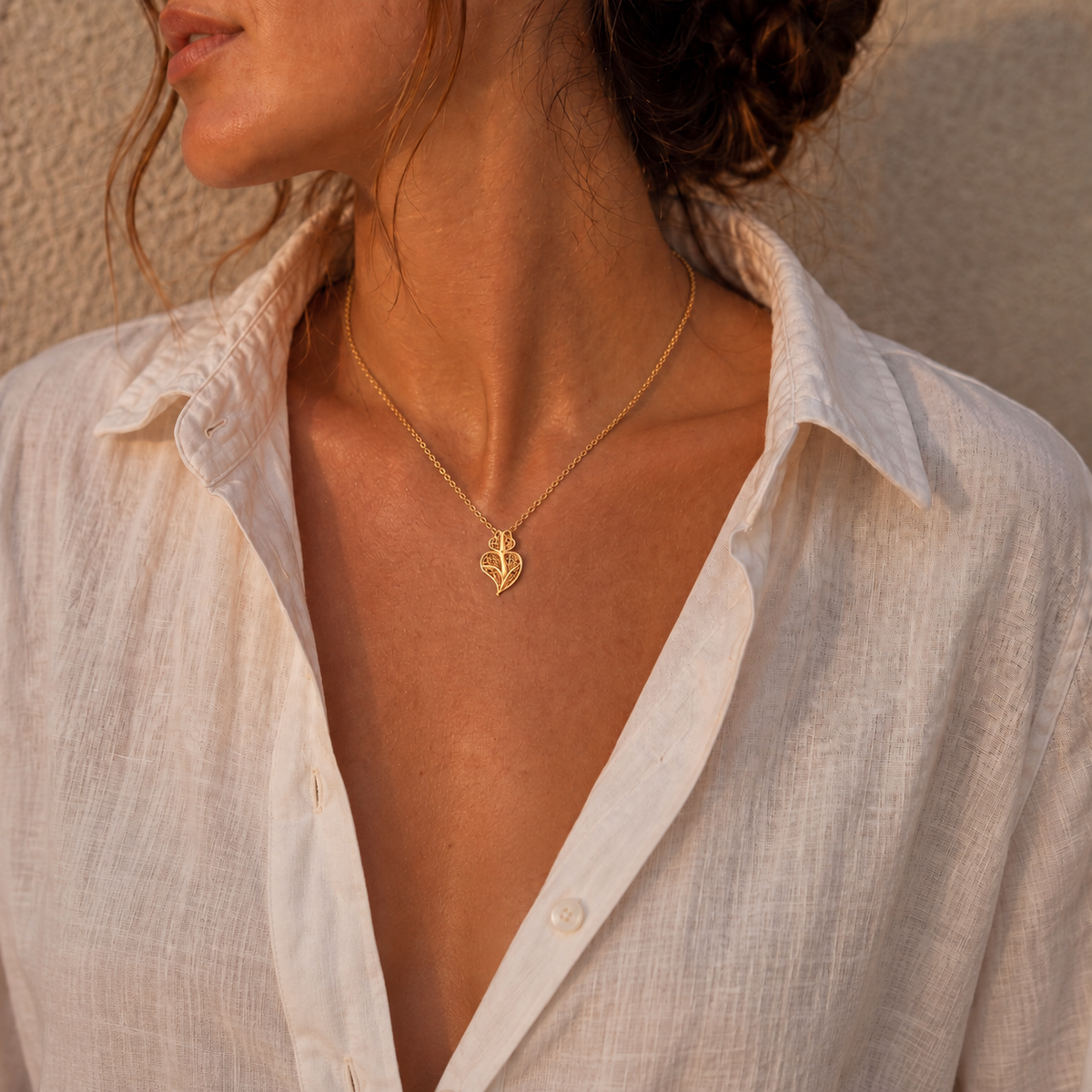 Heart of Viana gold necklace with a white linen shirt