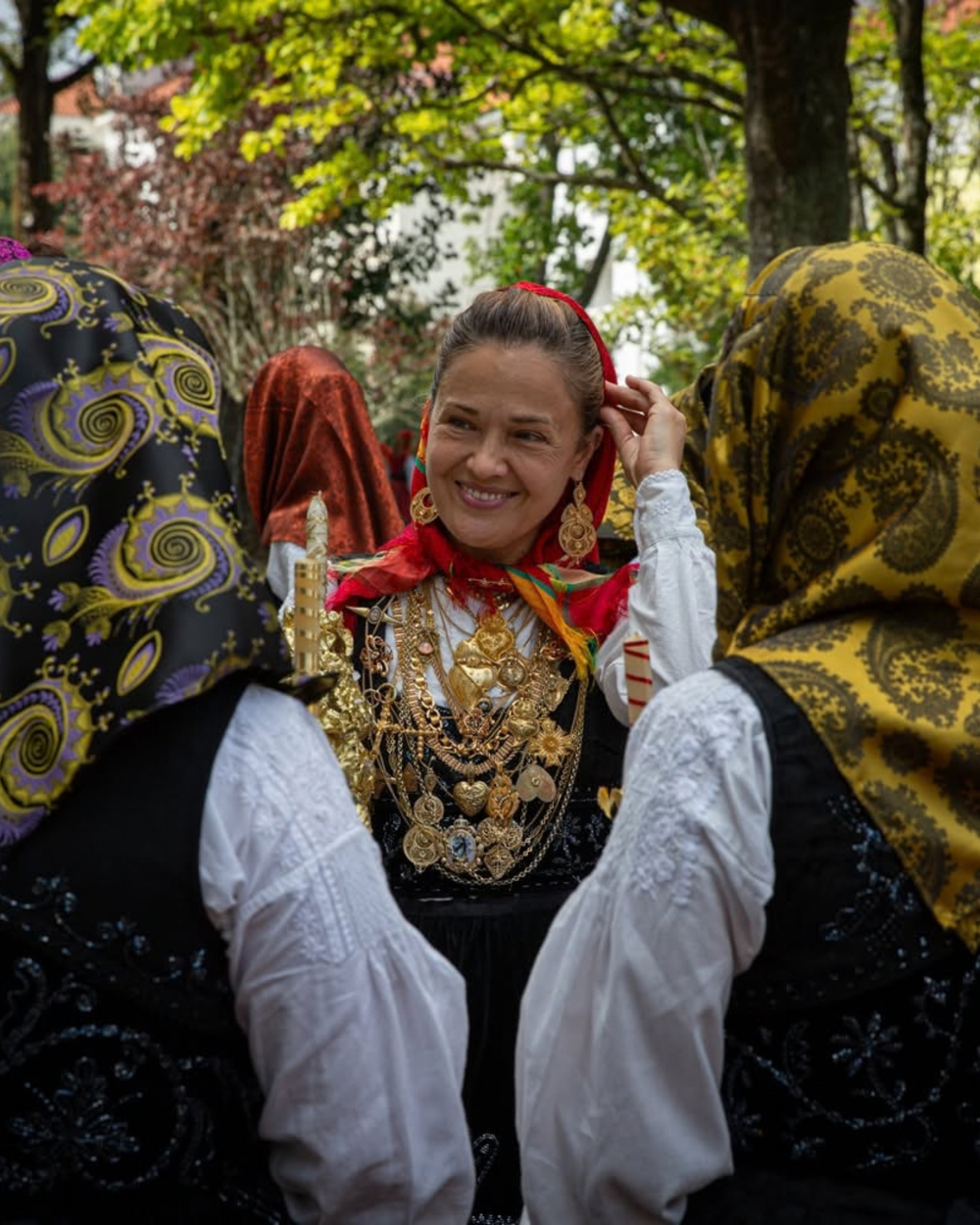 Woman in traditional dress wearing layers of gold at the Romaria